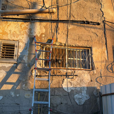 קיר חיצוני עם סולם וצינורות חשופים