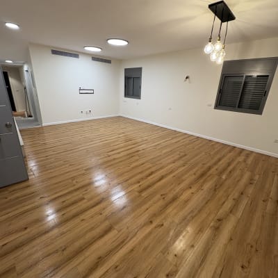 רצפת עץ מבריקה בחדר ריק עם תאורה מודרנית