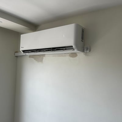 מזגן מותקן על קיר לבן עם שלט חשמלי