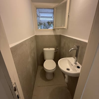 שירותים קטנים עם כיור וחלון פתוח