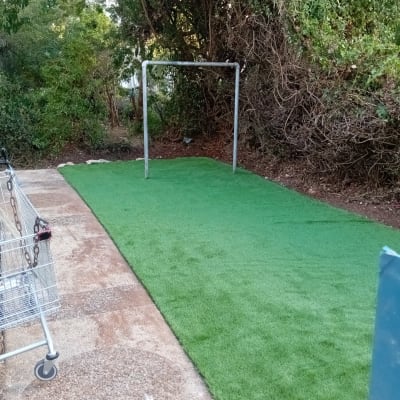 דשא סינתטי עם שער מתכת בגינה