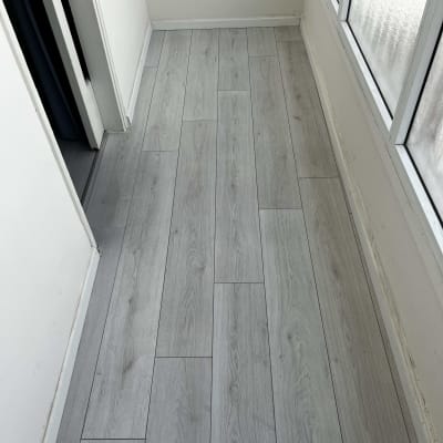 רצפת פרקט עץ בהירה במסדרון ליד חלון