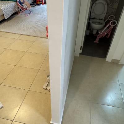 קיר צבוע בלבן עם רצפת אריחים