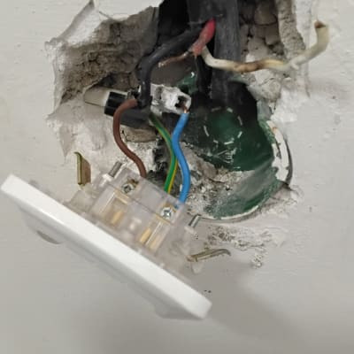 שקע חשמלי פתוח עם חוטים חשופים בקיר