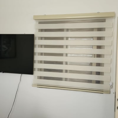 תריס ונציאני מותקן על חלון קיר לבן