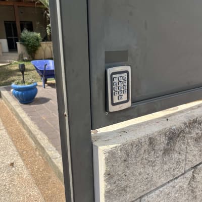 לוח מקשים של אינטרקום מותקן על שער מתכת