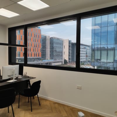 מחשב על שולחן משרדי עם כיסאות שחורים