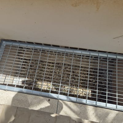 סורג מתכת מעל פתח עם אבנים קטנות