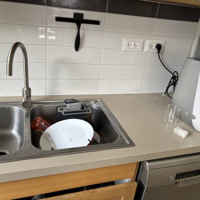 כיור מטבח עם כלים מלוכלכים וסבון כלים