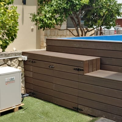 דק עץ חום ליד בריכה בגינה