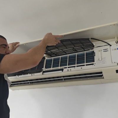 אדם מתקין מזגן על קיר לבן