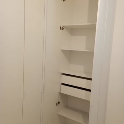 ארון לבן עם מדפים ודלתות פתוחות