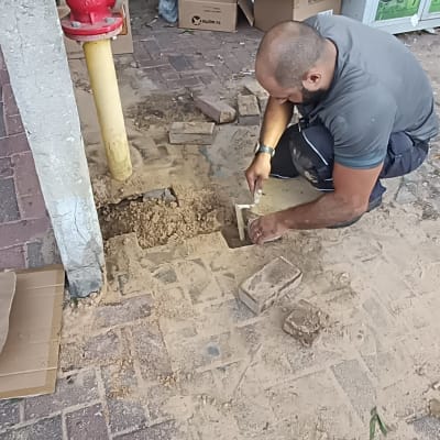 אדם עובד על תיקון צינור מים באדמה