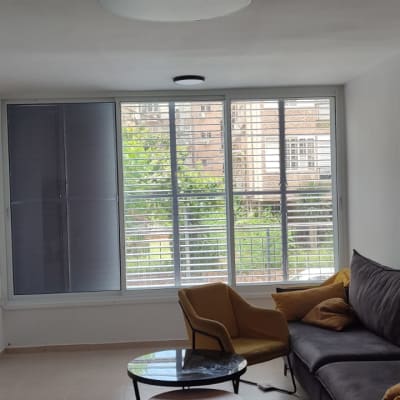 חלון עם תריסי אלומיניום בסלון מואר