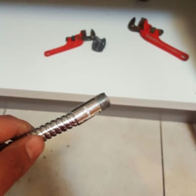 יד מחזיקה צינור מתכת, מפתח צינורות אדום ברקע