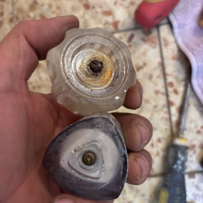 יד מחזיקה ידיות ברז ישנות עם כלים ברקע