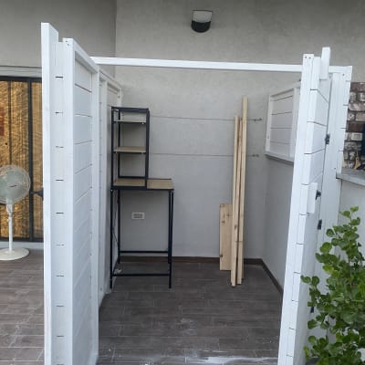 מבנה עץ לבן עם מדפים וקרשים בפנים