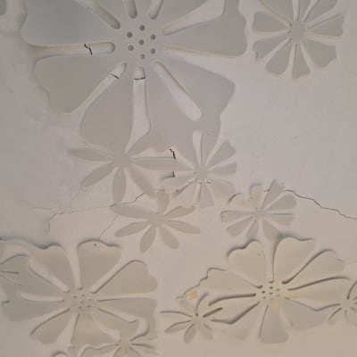 קיר עם עיטורי פרחים וסדקים