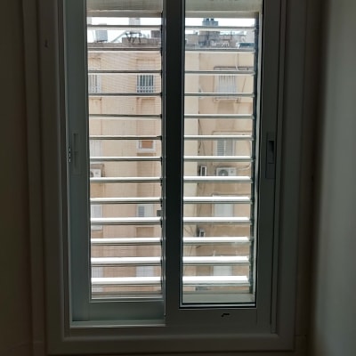 חלון עם תריסים אופקיים לבנים