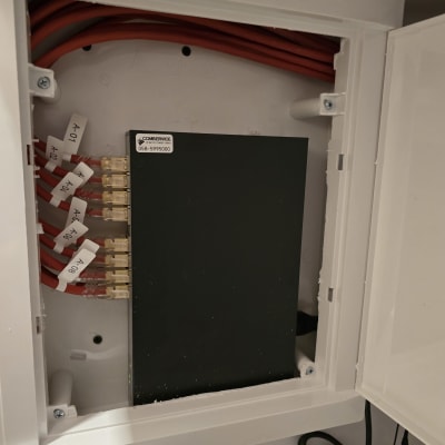 ארון תקשורת עם כבלים אדומים ומתגים מסומנים