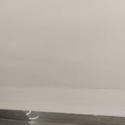 קיר לבן עם אריחים אפורים בתחתית