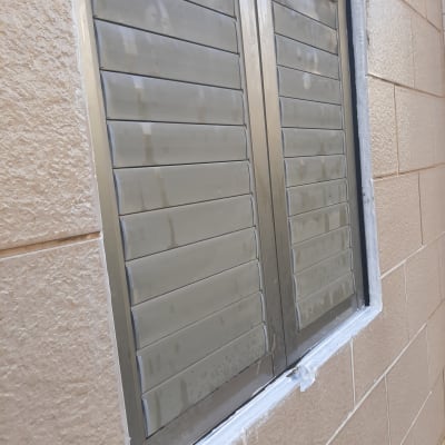 חלון אטום עם חומר איטום לבן סביב המסגרת