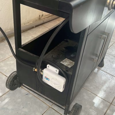 מכשיר גז עם צינור וחיבורים על רצפה מרוצפת