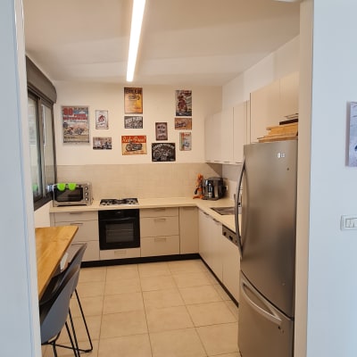 מטבח מודרני עם מקרר, תנור וכיסאות בר