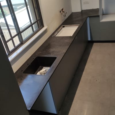 משטח שיש כהה במטבח עם כיור מובנה