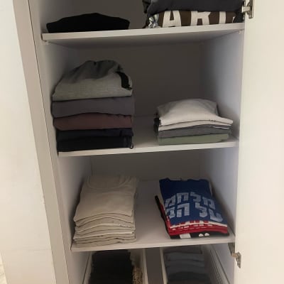 בגדים מקופלים בארון עם סלסלות אחסון
