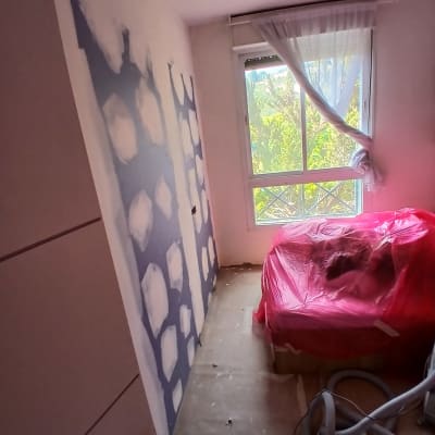 חדר עם קירות מטויחים וציוד מכוסה בניילון אדום