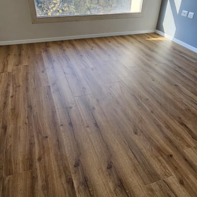 רצפת פרקט עץ בחדר מואר עם חלון גדול