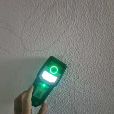 יד מחזיקה מכשיר מדידה על קיר