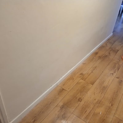 קיר צבוע בלבן עם רצפת עץ וכלי עבודה