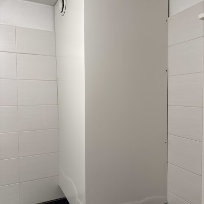 ארון לבן מותקן בפינת חדר אמבטיה