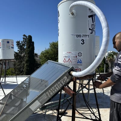 התקנת דוד שמש על גג עם טכנאי