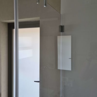 מגב תלוי על דלת זכוכית במקלחת