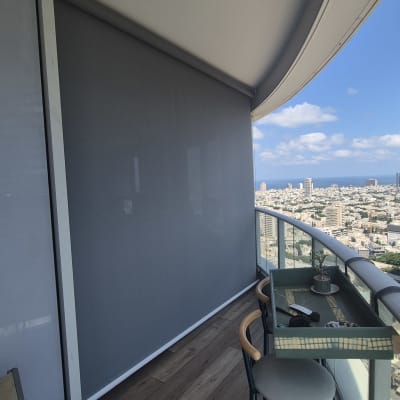 מרפסת עם סוכך נגלל ונוף עירוני
