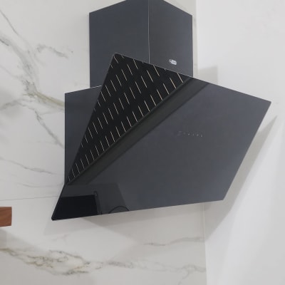 קולט אדים שחור מותקן על קיר לבן