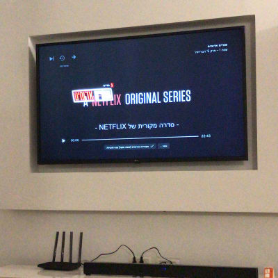 טלוויזיה תלויה על הקיר עם נתב ומזגן