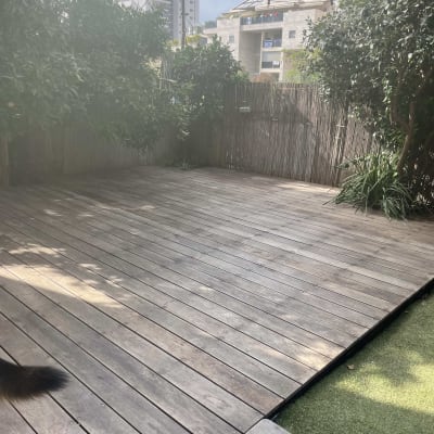 דק עץ בגינה עם צמחייה מסביב