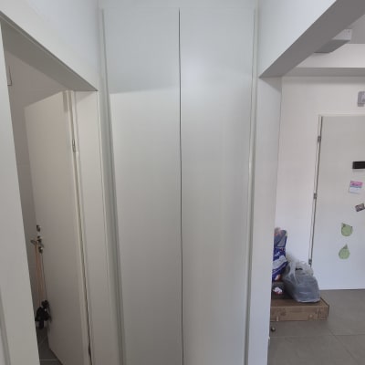 ארון לבן גבוה במסדרון עם דלתות סגורות