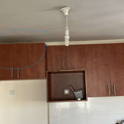 ארונות מטבח עם כלי צביעה על הקיר