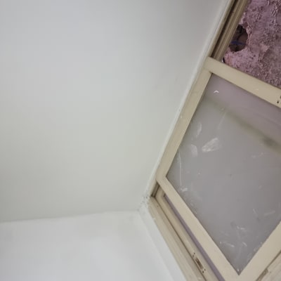 קיר צבוע ולידו חלון עם מסגרת ישנה