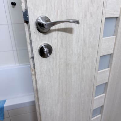 דלת עץ עם ידית מתכת בחדר אמבטיה