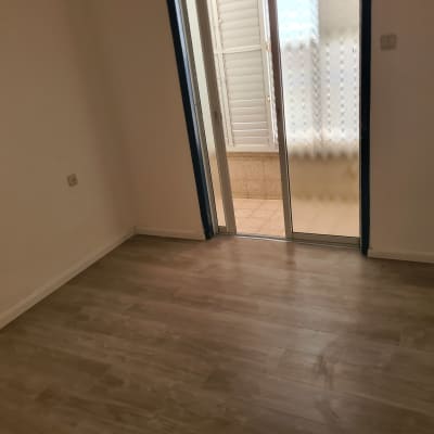 חדר ריק עם רצפת עץ ודלת זכוכית