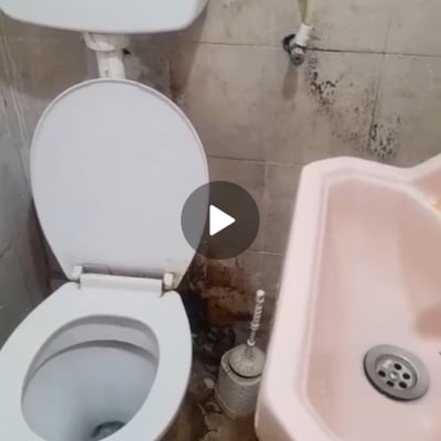 שירותים עם קירות מתקלפים וכתמי רטיבות