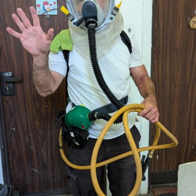 אדם עם מסכת מגן וציוד ריסוס