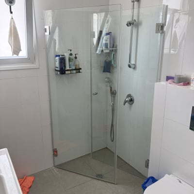 חדר אמבטיה עם מקלחון זכוכית וכלי רחצה