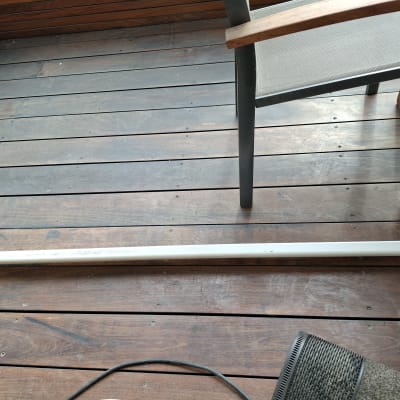 מוט מתכת על רצפת עץ ליד כיסא